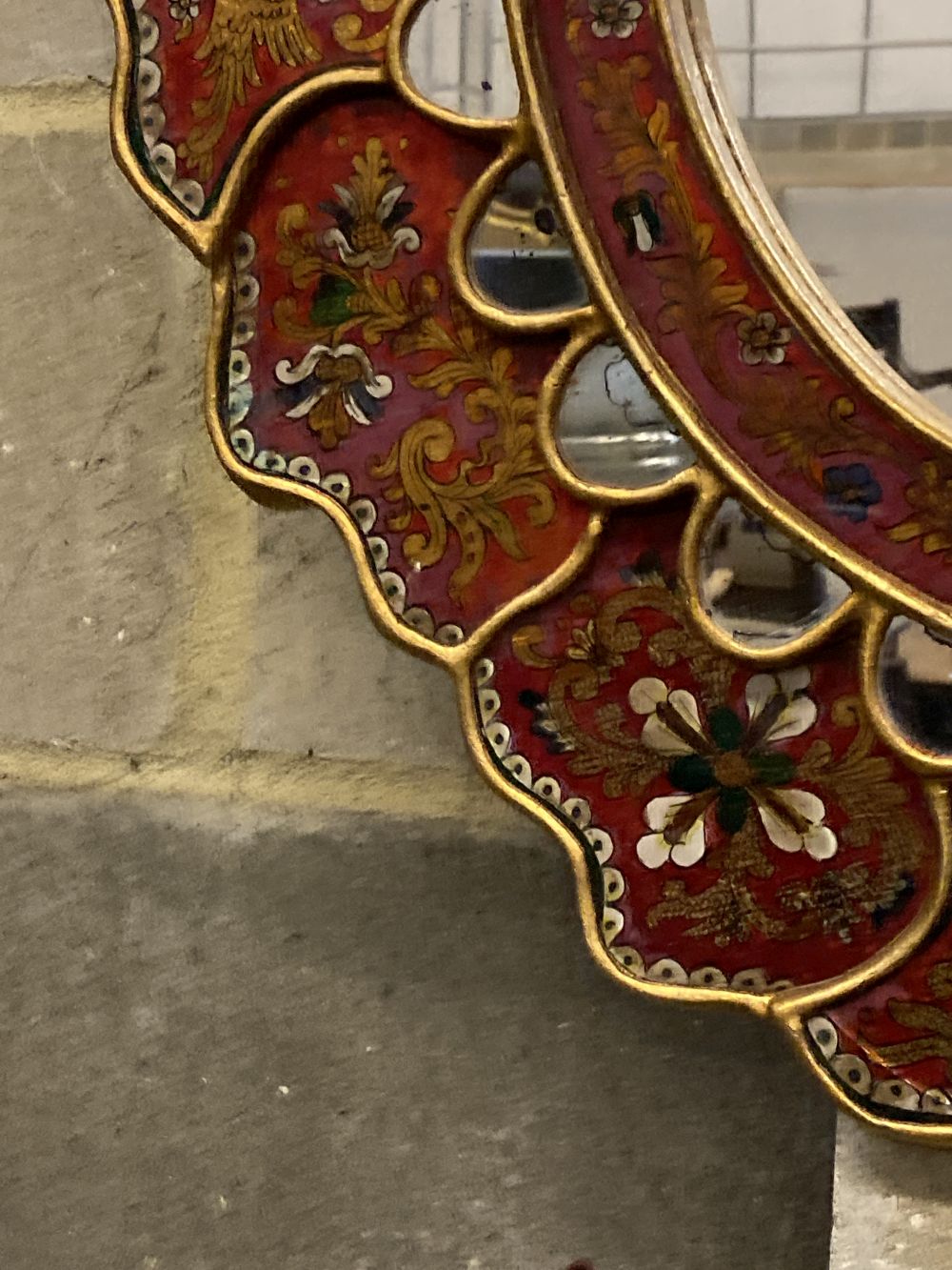 An Indian oval painted wall mirror, width 63cm, height 69cm